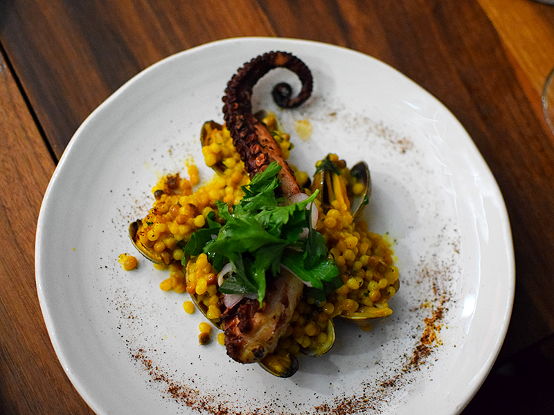 Martina signature dishes Grilled Octopus, Empanadas, various Wood-Fired Steaks, handmade pastas (e.g., Spaghetti with Crab), Potato Churros, Celery Root Ravioli.